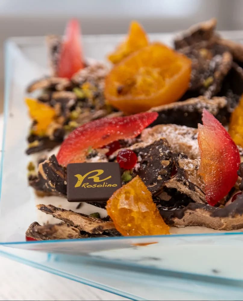 Dolce al piatto con frutta candita, cioccolato e targhetta Rosolino
