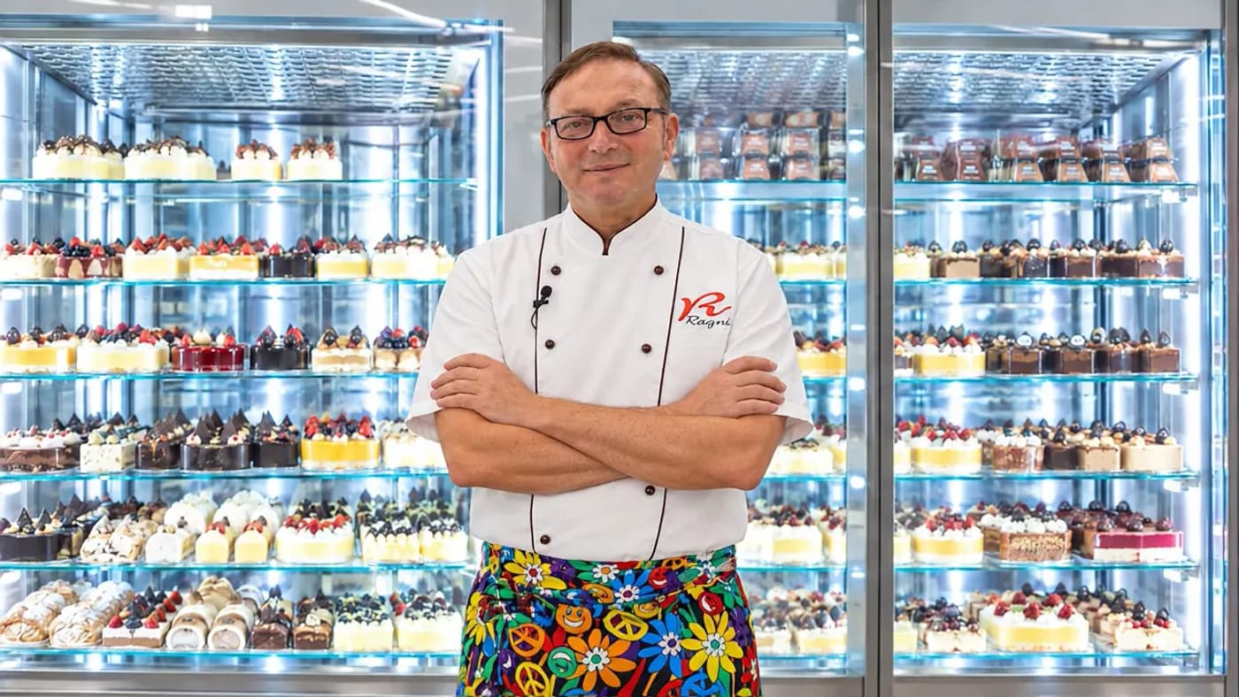 Luigi, maestro pasticcere, davanti alle vetrine refrigerate della pasticceria